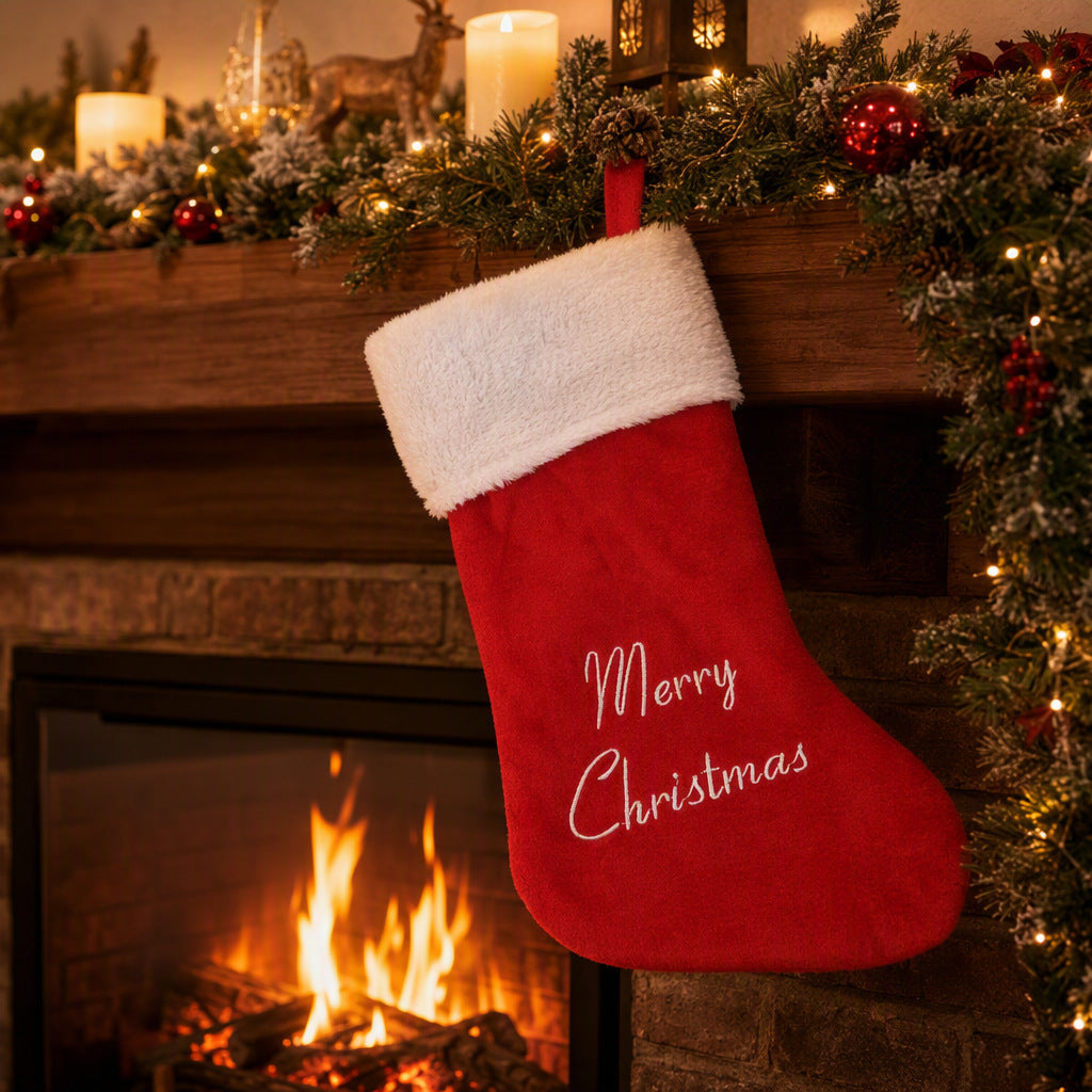 Red Merry Christmas stocking beside a fireplace