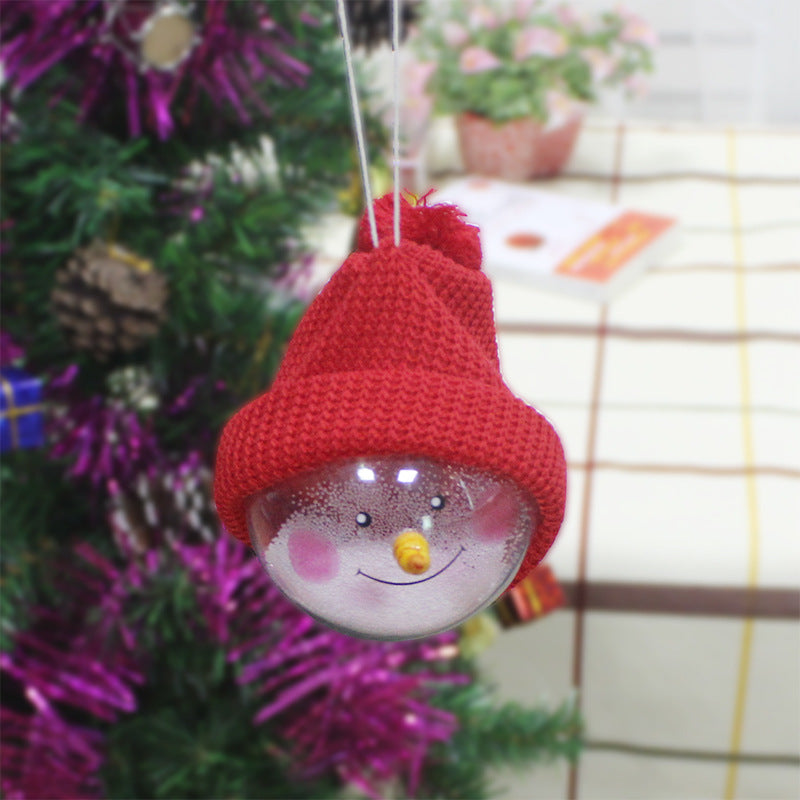 Red-hat snowman ornament hanging on a tree