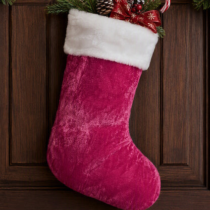 Dark pink stocking with white cuff hanging on a door