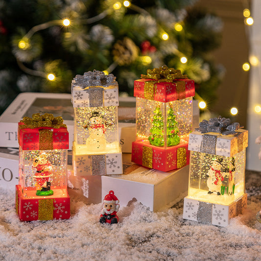 Lighted Christmas gift box snow globes in a holiday display