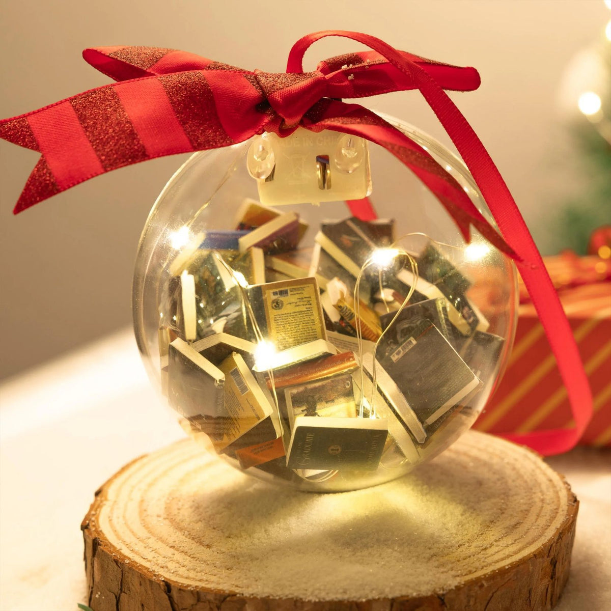 Book-filled bauble with red ribbon on a display stand