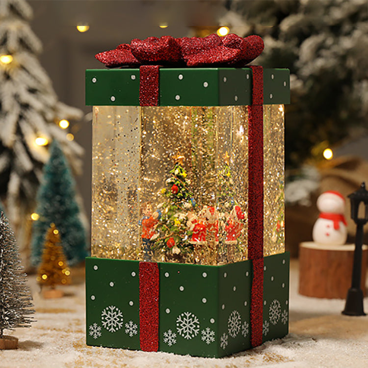 Green lighted gift box beside seasonal decorations
