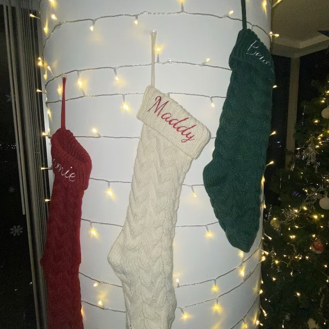 Cream and green knit stockings on a stair rail